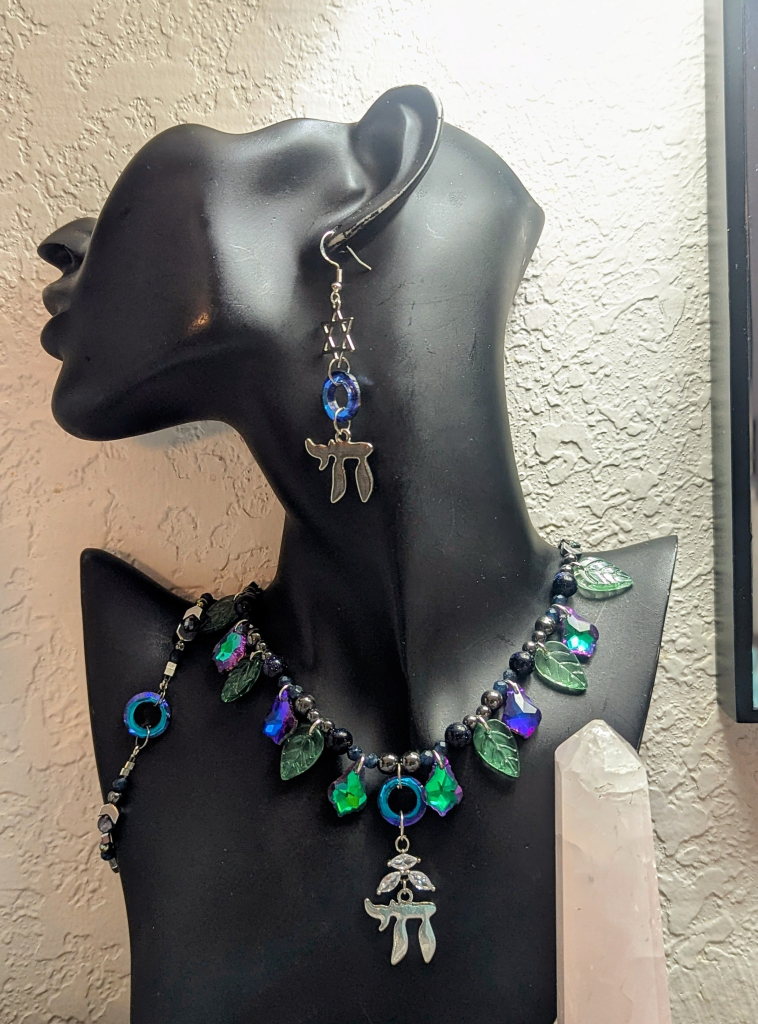 A purple green faceted glass and white zirconia shimmering set with silver Chai pendant and faceted blue glass earrings with chai and Magen and fitting bracelet