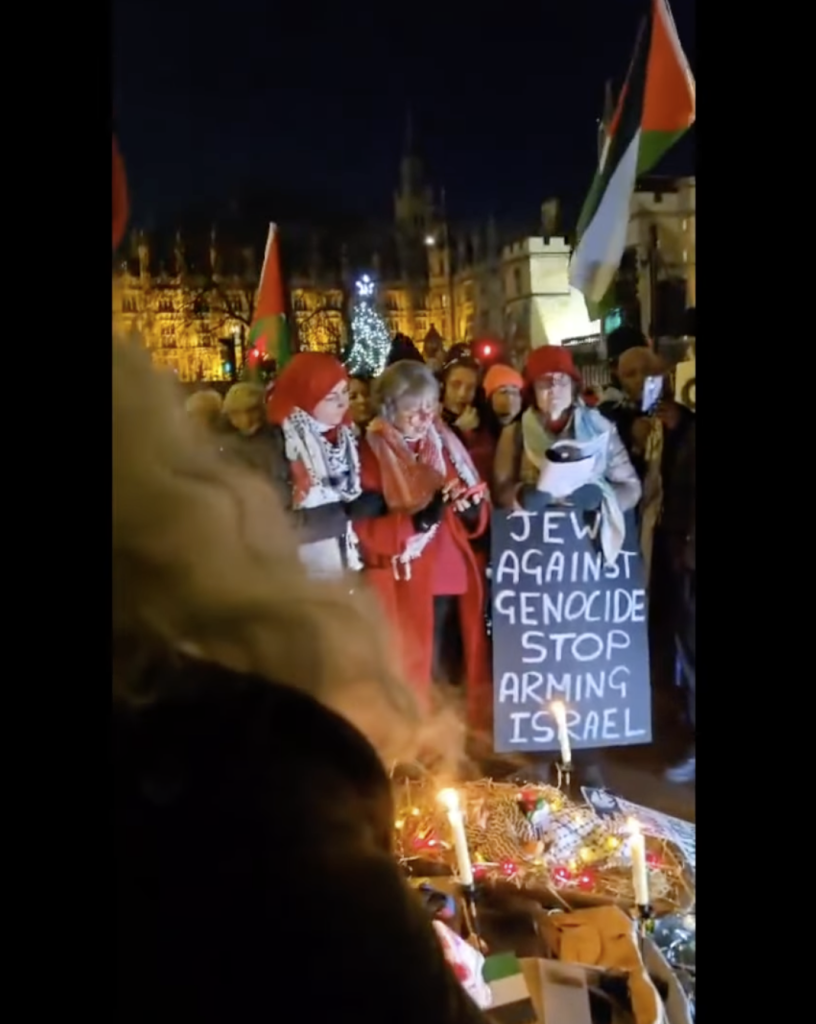 interfaith group outside parliament praying for peace

led by a christian pastor

"jews against genocide stop arming Israel" says one poster