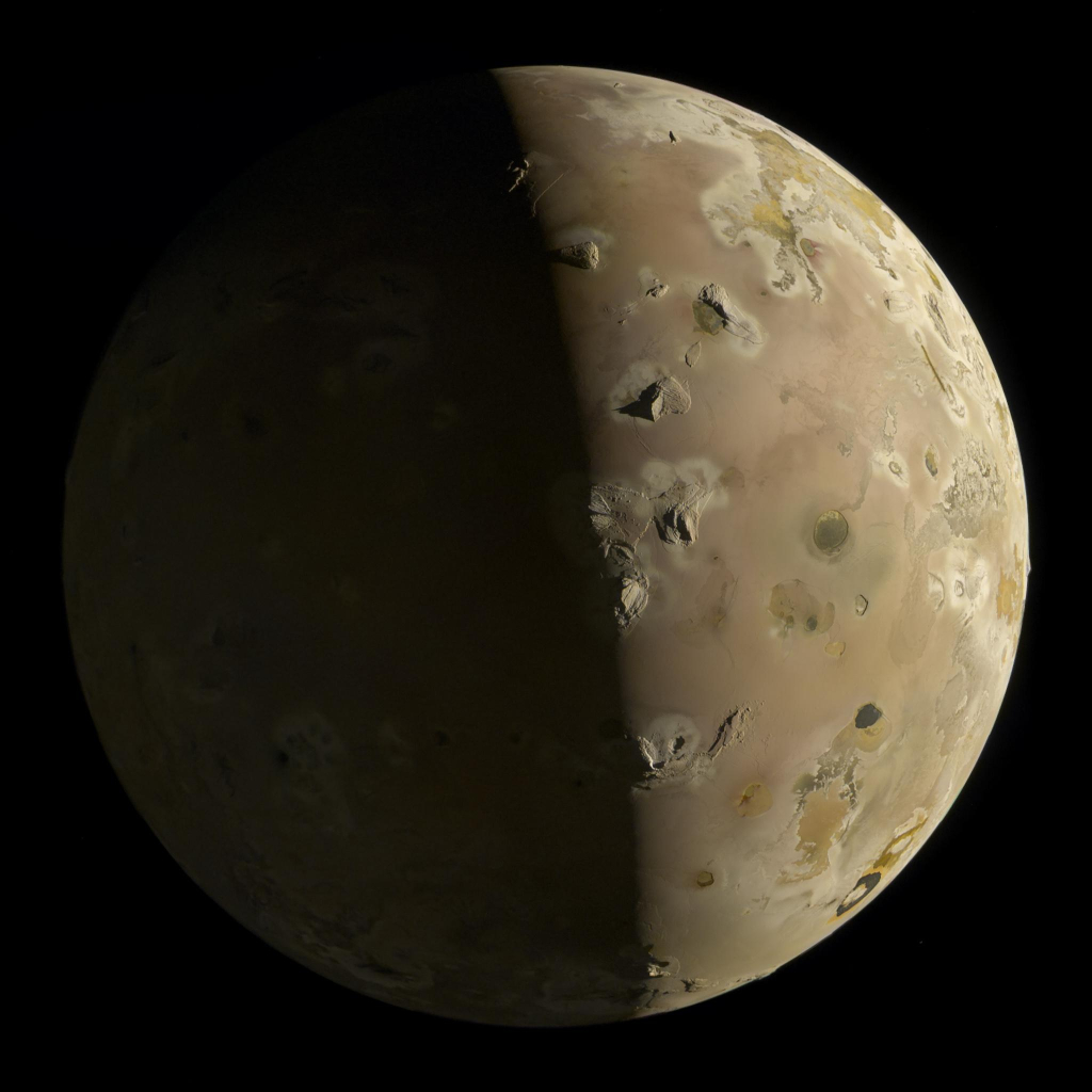 Half lit image of the Jupiter moon Io showing a soft beige surface with greenish surfaces mixed in. Sharp mountains stand out against the otherwise smooth surface and cast long shadows near the terminator line. Black lava features are scattered around on the surface, one of them has a horseshoe shape.
The shadowed side of the moon is dimly lit by Jupiter and was slightly brightened during processing to show some faint surface features.

Credit: NASA / JPL-Caltech / SwRI / MSSS / Simeon Schmauß