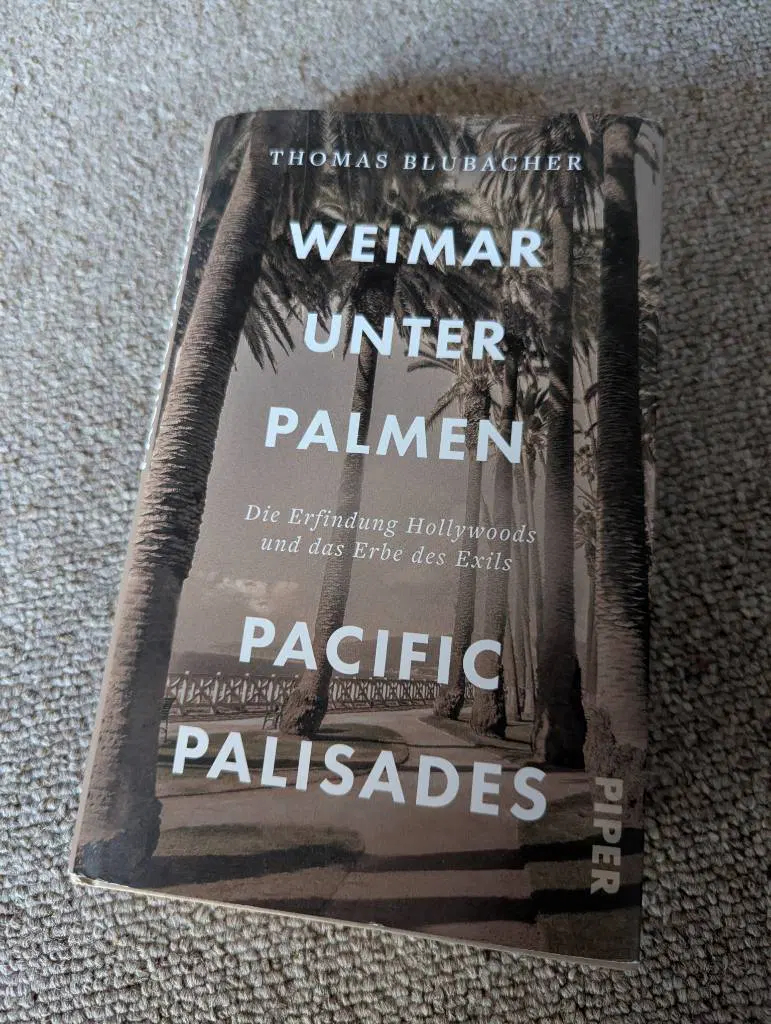 Cover des Buches:
Weimar unter Palmen
Die Erfindung Hollywoods und das Erbe des Exils
Pacific Palisades
Der Titel steht auf einem sepiafarbenen Bild einer Strandpromenade mit großen Palmen