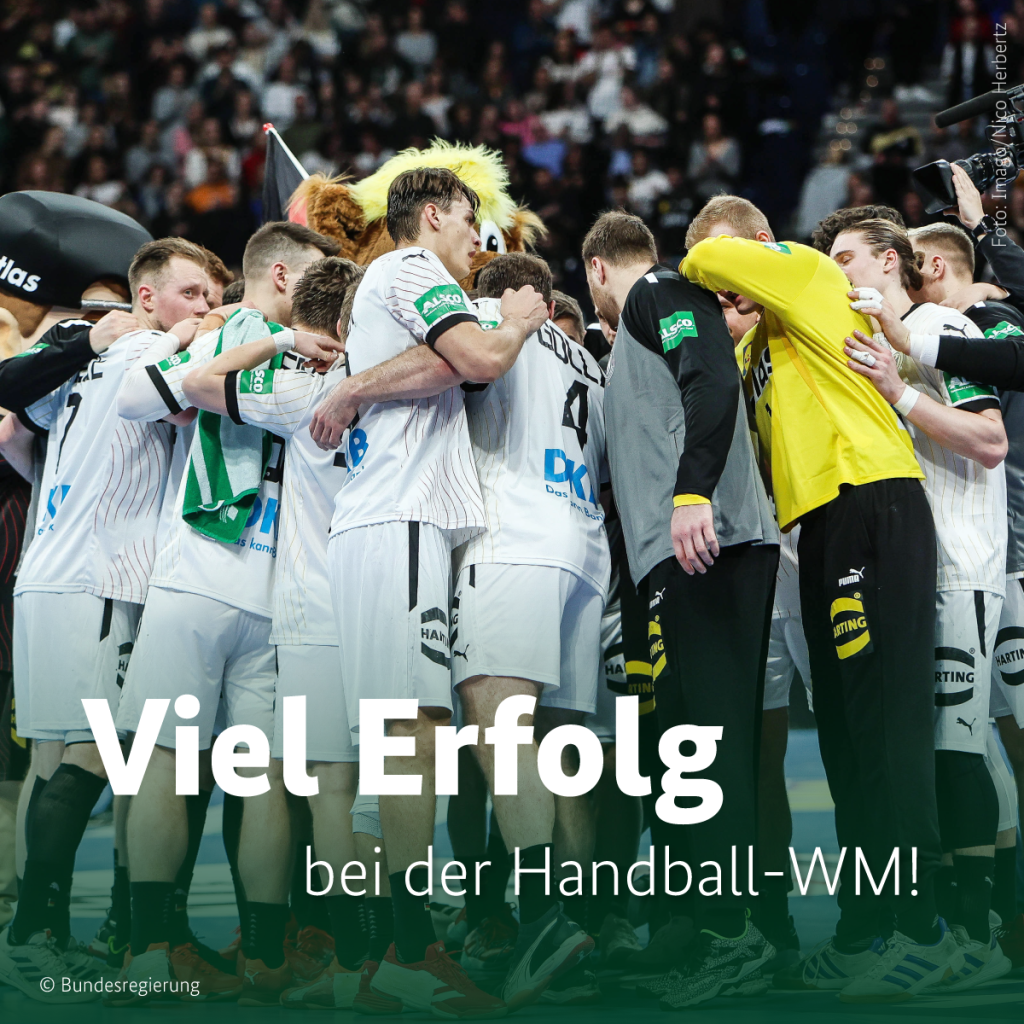 Viel Erfolg bei der Handball-WM! Foto von der Herren Handball Nationalmannschaft, wie sie im Kreis stehen und sich zum Teil die Arme umlegen.