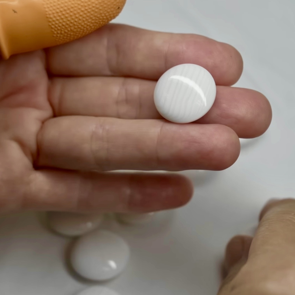 Hand selected white sea shells are cut and polished into Go pieces in Japan