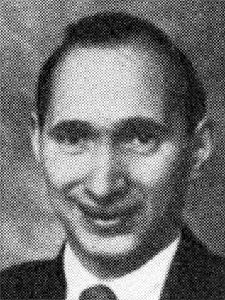 Black and white yearbook photo of a smiling man with short hair.