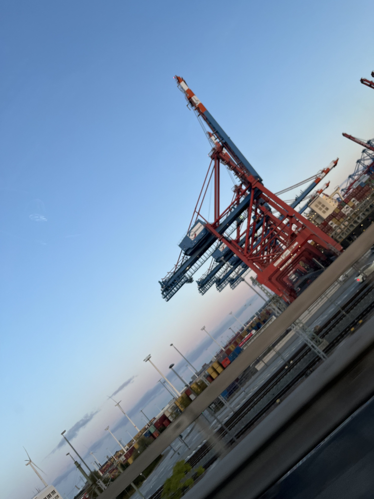 Schräges Foto von der Autobahn aus aufgenommen, roter Industrie Kran im Containerhafen von Hamburg