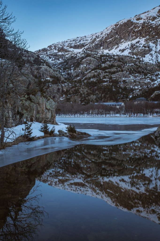 Vertical photography of a winter landscape in the Pyrenees. The place is a natural lake in Panticosa (Huesca). You can see some mountains and part of the lake with snow and ice.