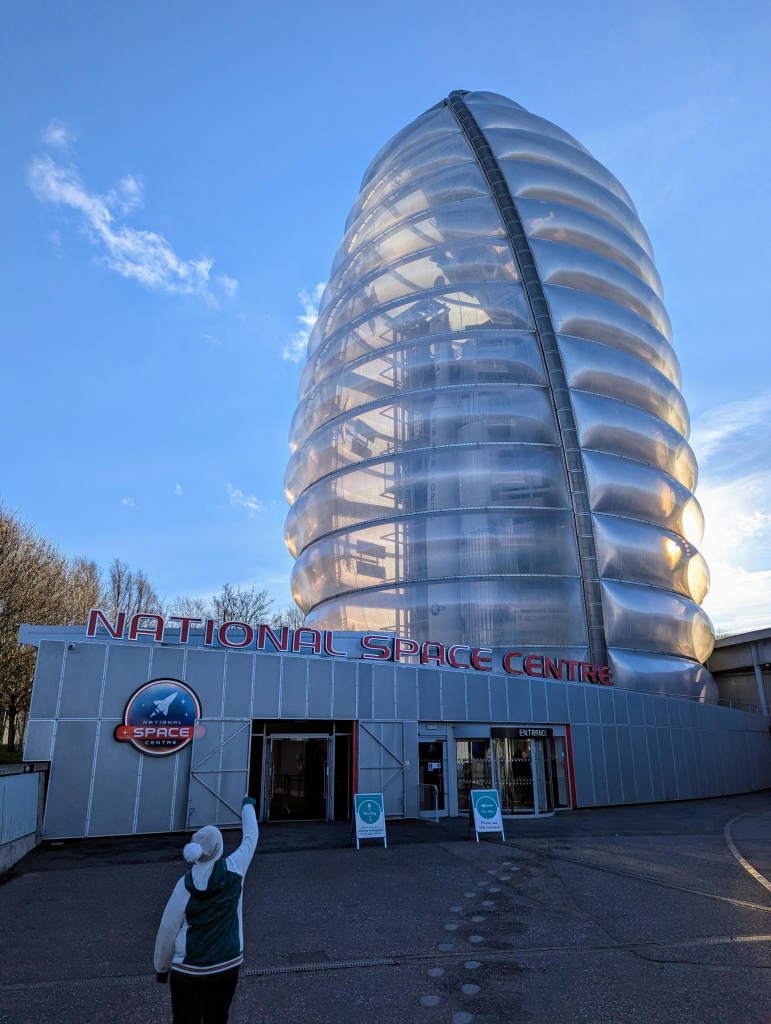 Photo of the National Space Centre in Leicester, featuring the translucent Rocket Tower building. Thor Able and Blue Streak rockets can be seen through the plastic skin of the building.