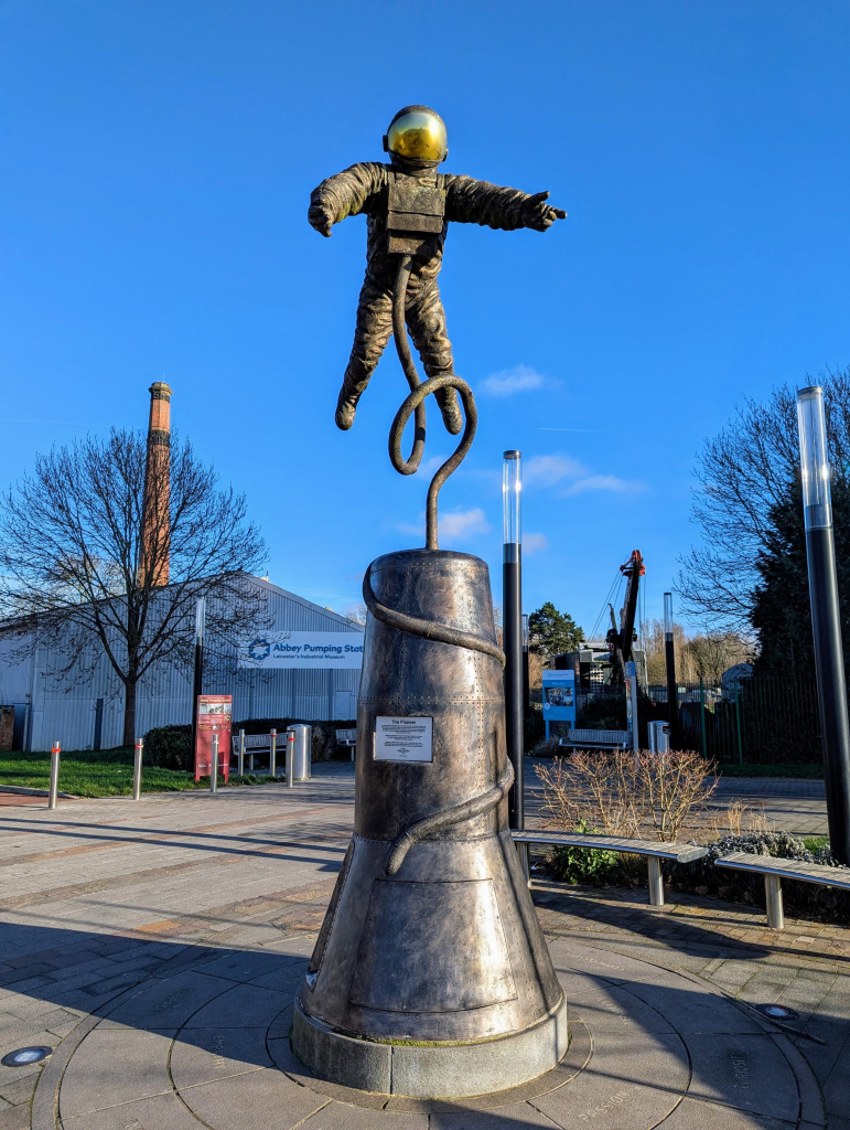 Photo of "The Pioneer" sculpture at the National Space Centre, dedicated to Ed White. The sculpture is off an astronaut apparently floating above a Mercury capsule.