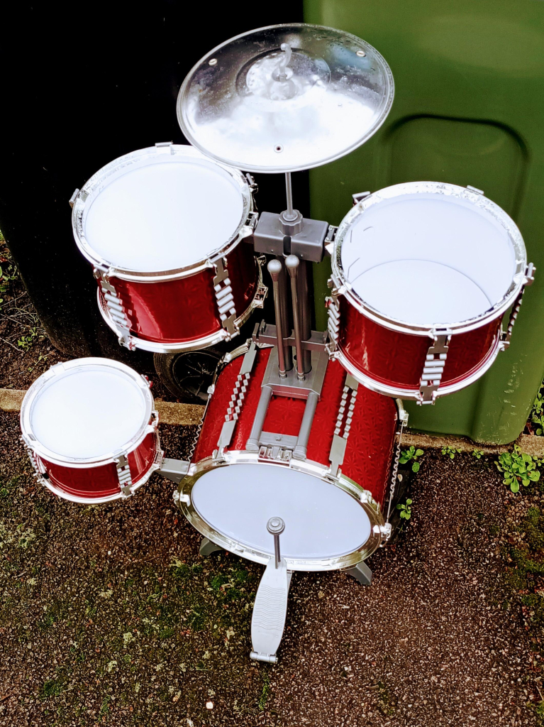 A children's red drum set, left out for the bin men. One skin is broken but otherwise it looks good. 
