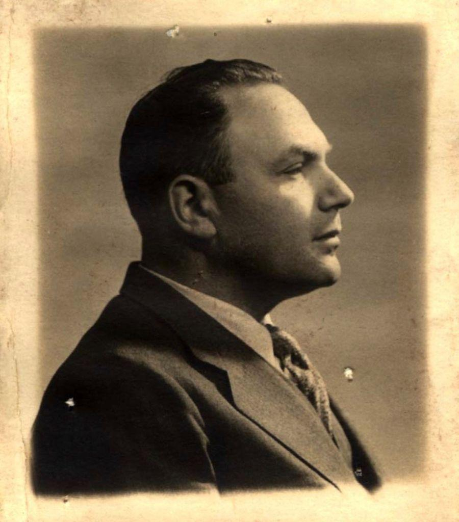 Vintage sepia-toned portrait of an adult man in a suit, shown in profile.
