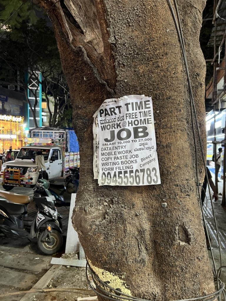 Ein Zettel an einem Baum. Es werden Personen für „mobile work“, 
„copy paste job“, „writing books“ und 
„form filling“ gesucht.