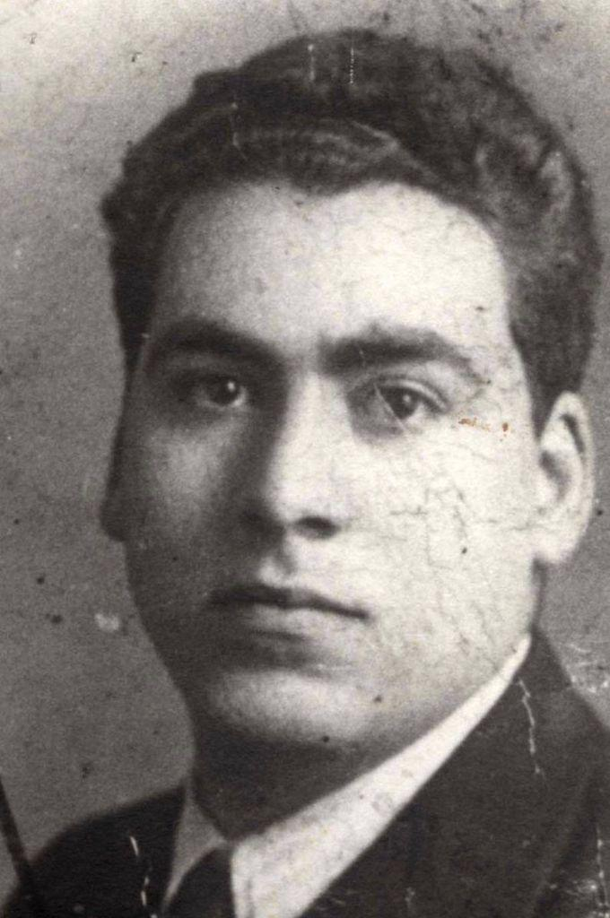 Black and white portrait of a young man in a suit and short curly hair.