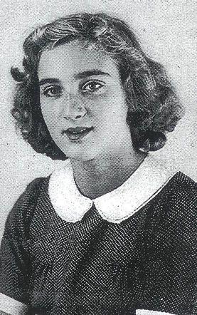 Black and white photograph of a girl with curly hair, wearing a collared dress and looking directly at the camera.