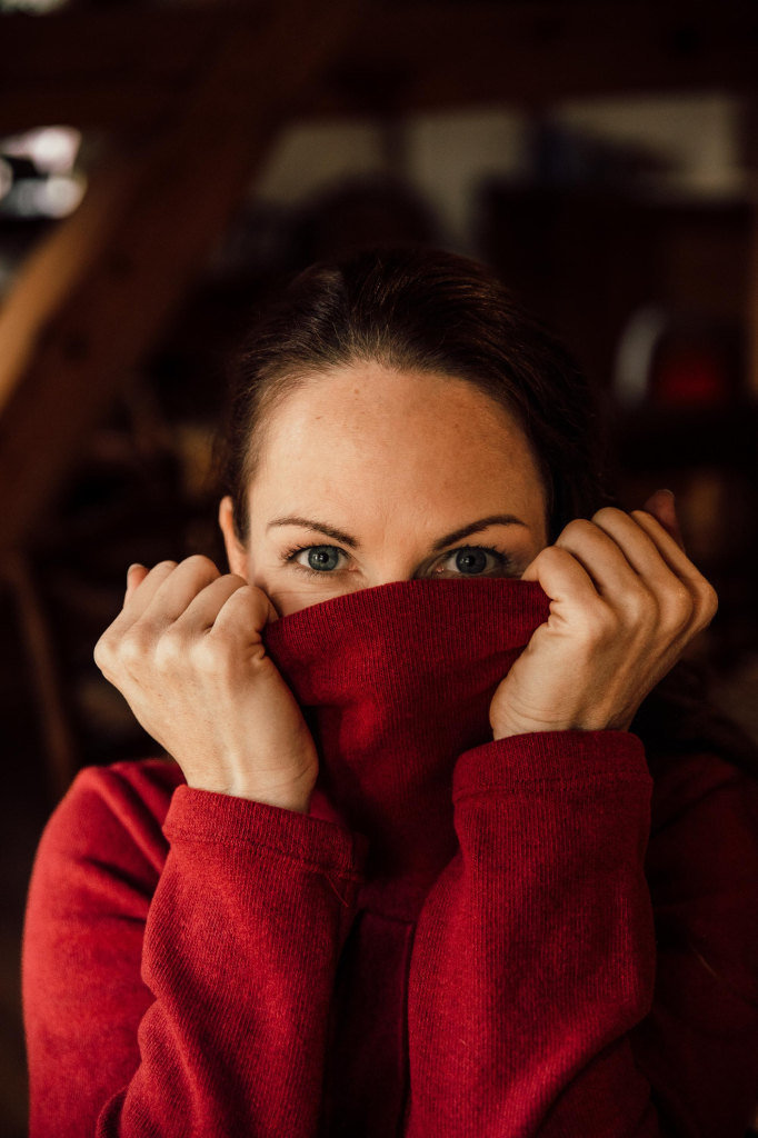 Portrait with red hoodie, with half face in the collar