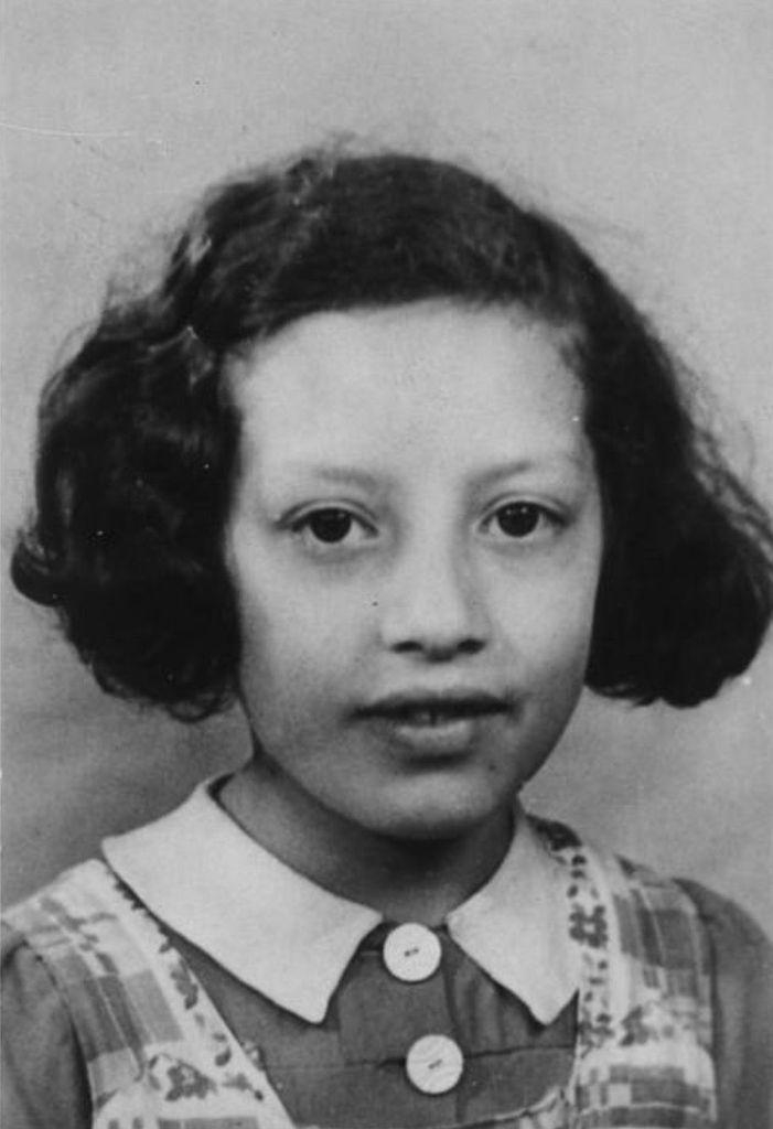 Black and white portrait of a young girl, showing her wearing a collared dress and her hair styled in curls.