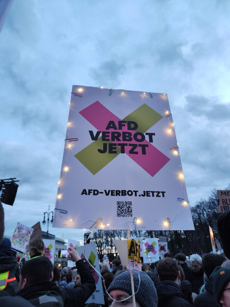 Menschen demonstrieren vor dem Brandenburger Tor mit AfD-Verbotsschildern