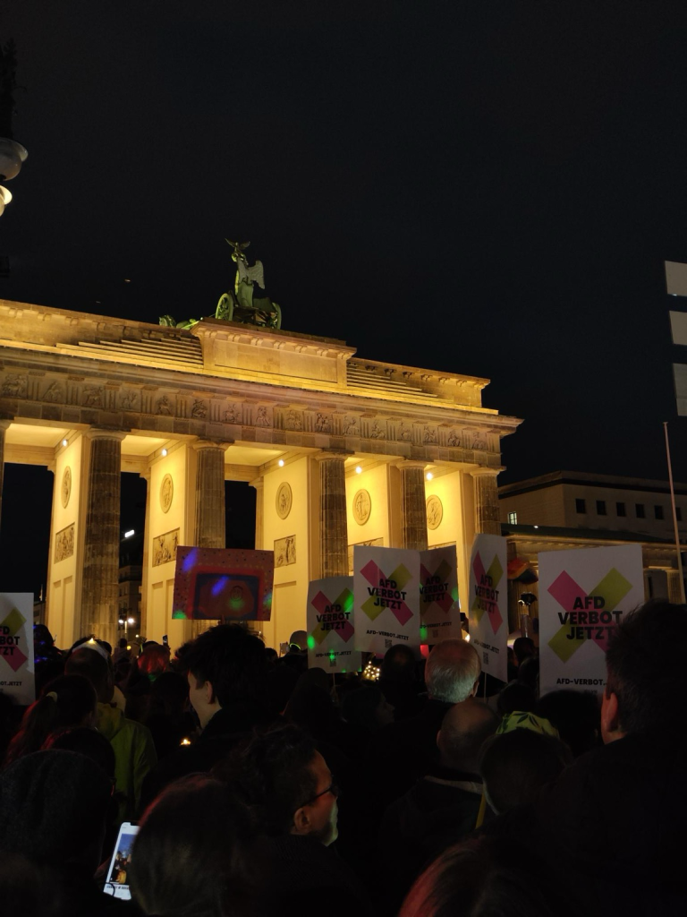 Menschen demonstrieren vor dem Brandenburger Tor mit AfD-Verbotsschildern