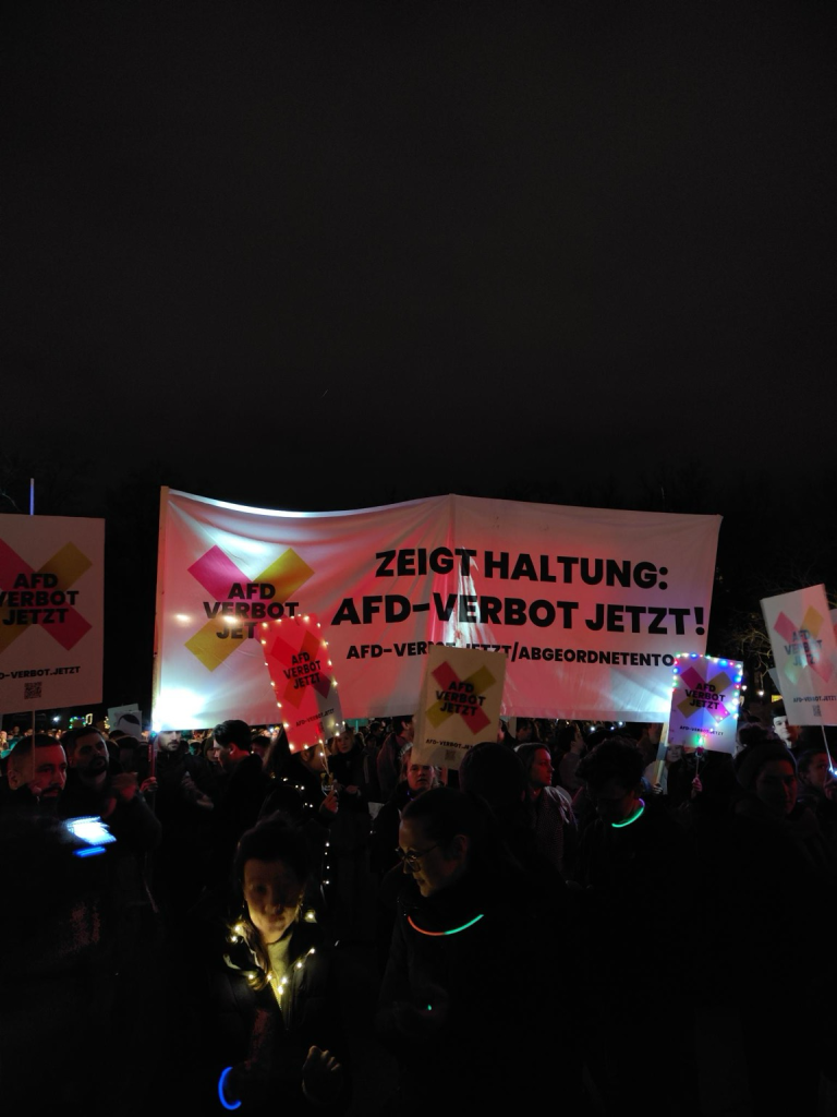 Menschen demonstrieren vor dem Brandenburger Tor mit AfD-Verbotsschildern