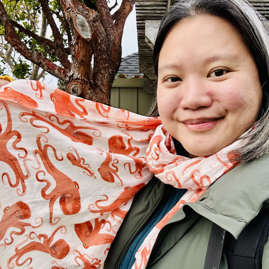 Photo of a person holding up a scarf that has prints of octopus