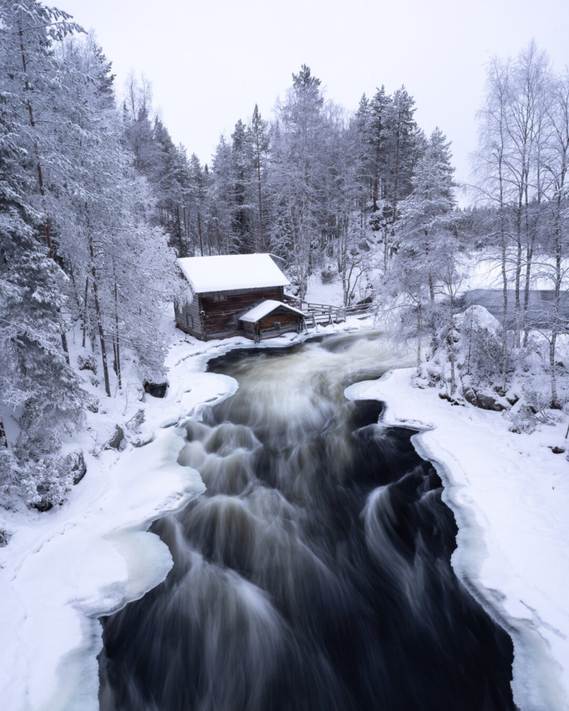 River from above leading to a small wooden building.