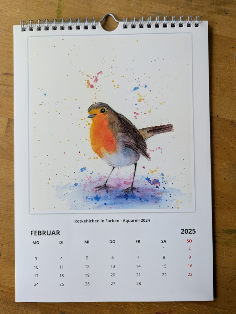 Calendar sheet for February featuring my painting Robin in Colors - a hand-painted watercolour painting in portrait format .
A European Robin stands amidst splashes of vibrant colors on a plain creamy white background. The bird's bright orange breast contrasts beautifully with its darker feathers.. The colours of the plumage are repeated in the splashes of colour in the abstract background. The songbird looks in a friendly manner towards the viewer.