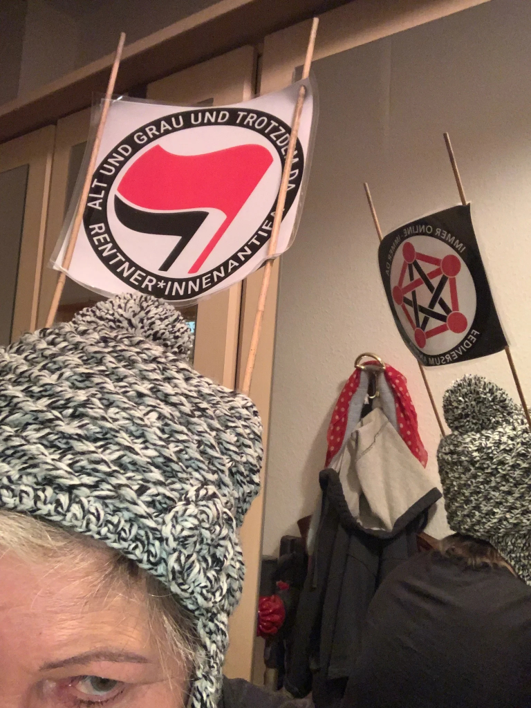 An meiner BommelMütze ist ein Gestell mit Antifa-Stickern befestigt 