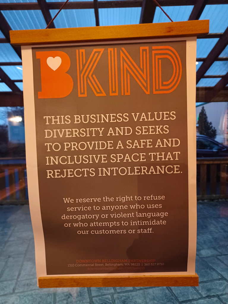 Poster on the window of a business that reads B KIND. This business values diversity and seeks to provide a safe and inclusive space that rejects intolerance. We reserve the right to refuse service to anyone who uses derogatory or violent language or who attempts to intimidate our customers or staff.
Downtown Bellingham Partnership, 1310 Commercial Street, Bellingham, WA
