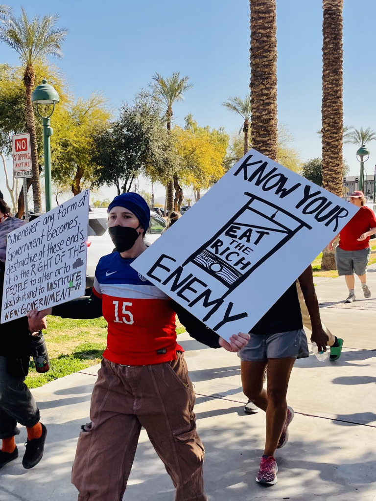 Sign reads no you are enemy. It’s a guillotine with eat the rich written on it.