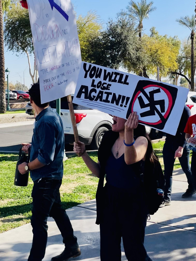 The sign shows a swastika with a slash through it and reads “you will lose again!!”