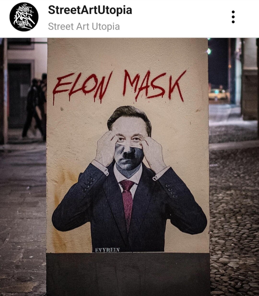 Street art showing musk pulling up his face to reveal hitlers face titled Elon Mask, post by StreetArtUtopia 