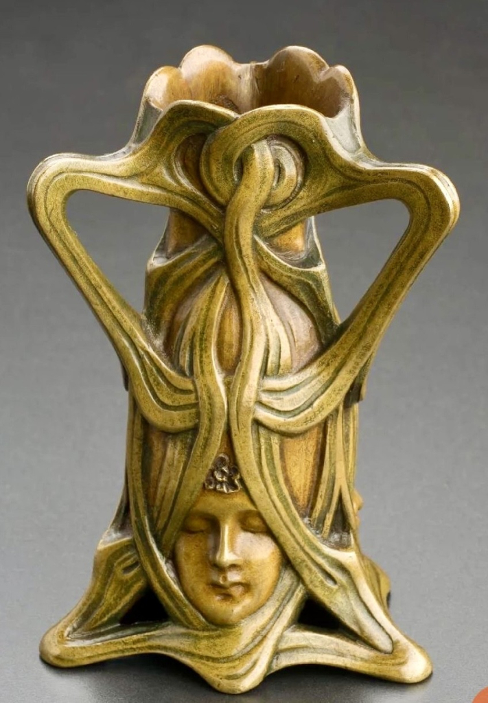 A photo of an Art Nouveau ivory goblet. The design features a woman’s face, and the handles and base are formed from the woman’s twisted hair.