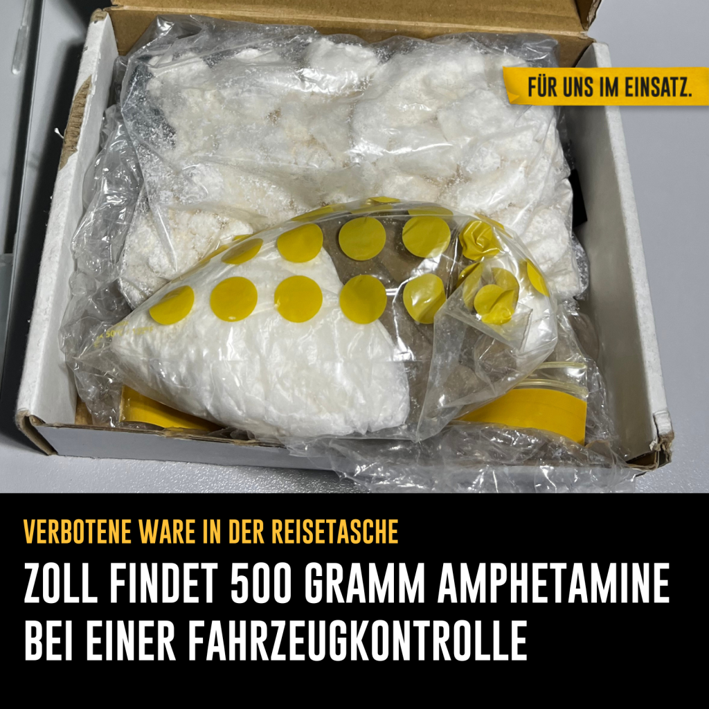 In einer Pappschachtel befinden sich zwei Plastiktüten mit einem weißen Pulver als Inhalt. Text: Verbotene Ware in der Reisetasche - Zoll findet 500 Gramm Amphetamine bei einer Fahrzeugkontrolle.