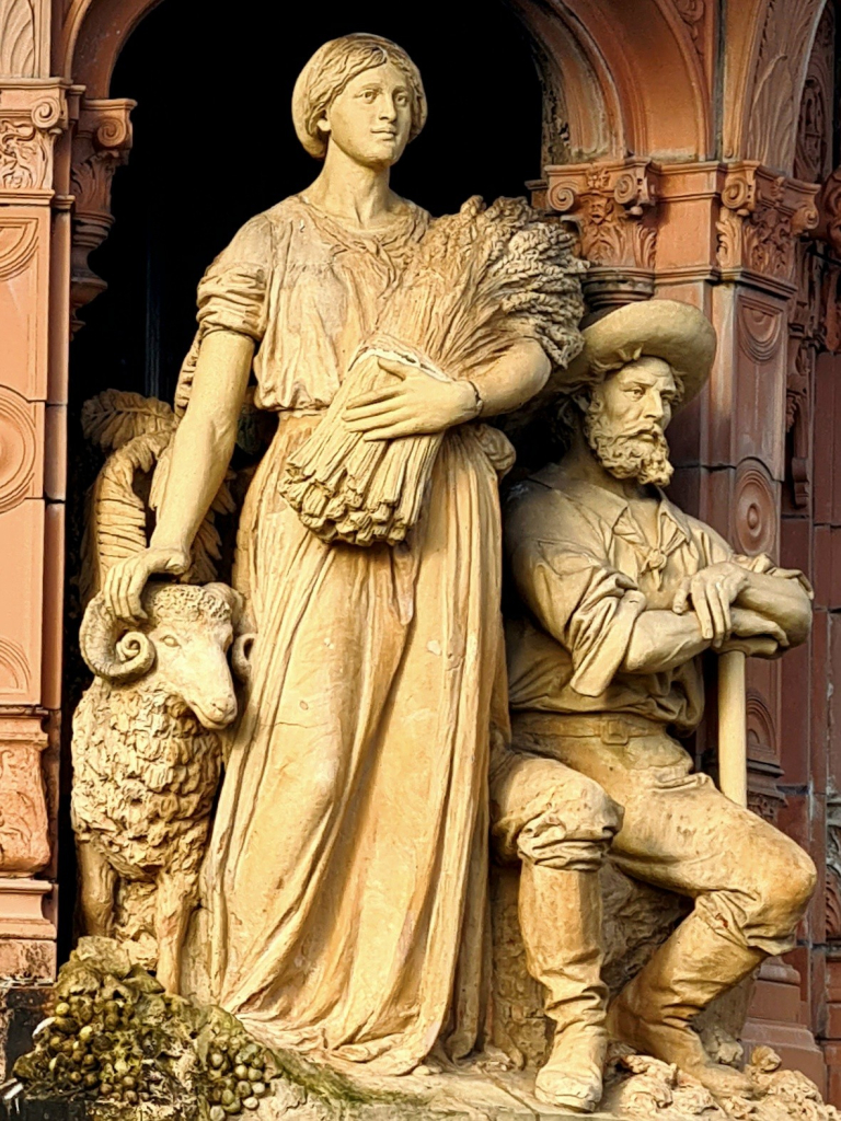 Statues of an Australian man, woman and sheep on a Victorian fountain in Glasgow.