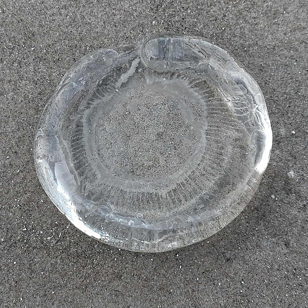 A block of ice holding the imprint of a jellyfish. There's something weird about the organic shape in combination with the ice