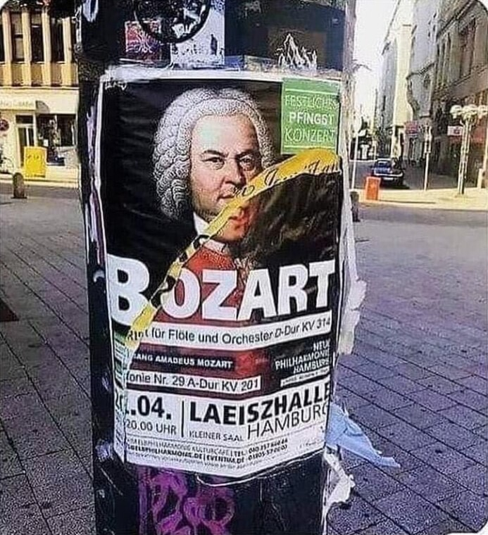 telephone poll with posters stapled one on top of the other. The top one has been ripped in half diagonally. It shows Bach's upper face, and has the letter b. The poster underneath shows Mozart's lower face and the letters OZART. Bozart