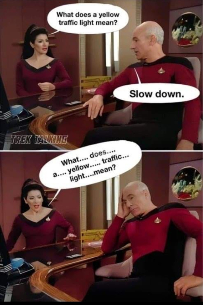 Two-panel meme with a scene from Star Trek: The Next Generation. Picard is seated in his Ready Room, and Counselor Troi is seated across the desk from him.

Troi is asking, "What does a yellow traffic light mean?"

Picard answers, "Slow down."

Troi says, "What... does... a... yellow... traffic... light... mean?"