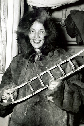 Caroline Mikkelsen in her cold weather gear, holding a model sled. She is a white woman.