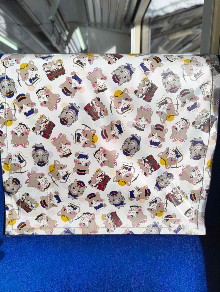 Antimacassar with super-deformed/chibi cartoon illustrations of the Aizu Railway’s cats who live at Ashinomaki Onsen station 