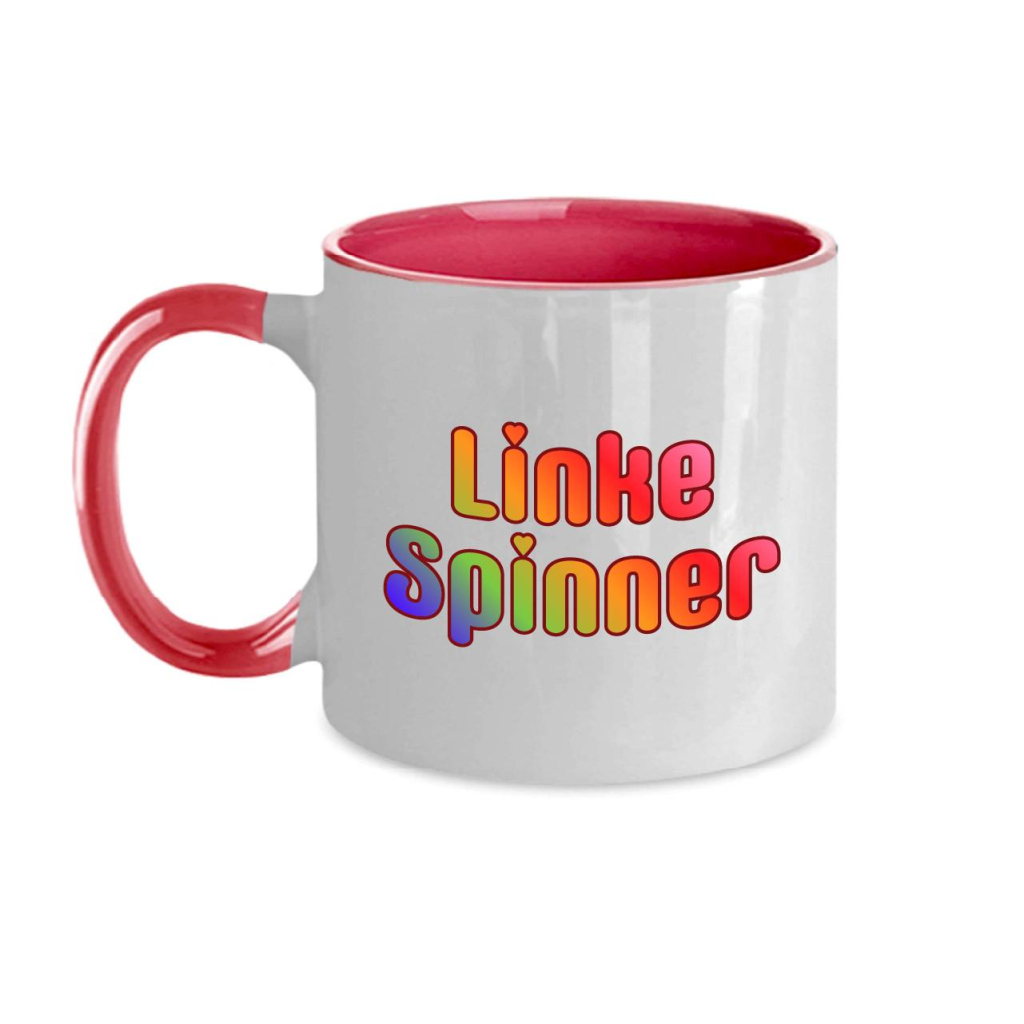 Mockup einer Tasse mit dem Schriftzug "Linke Spinner" in Regenbogenfarben und mit Herzchen-i-Pünktchen.