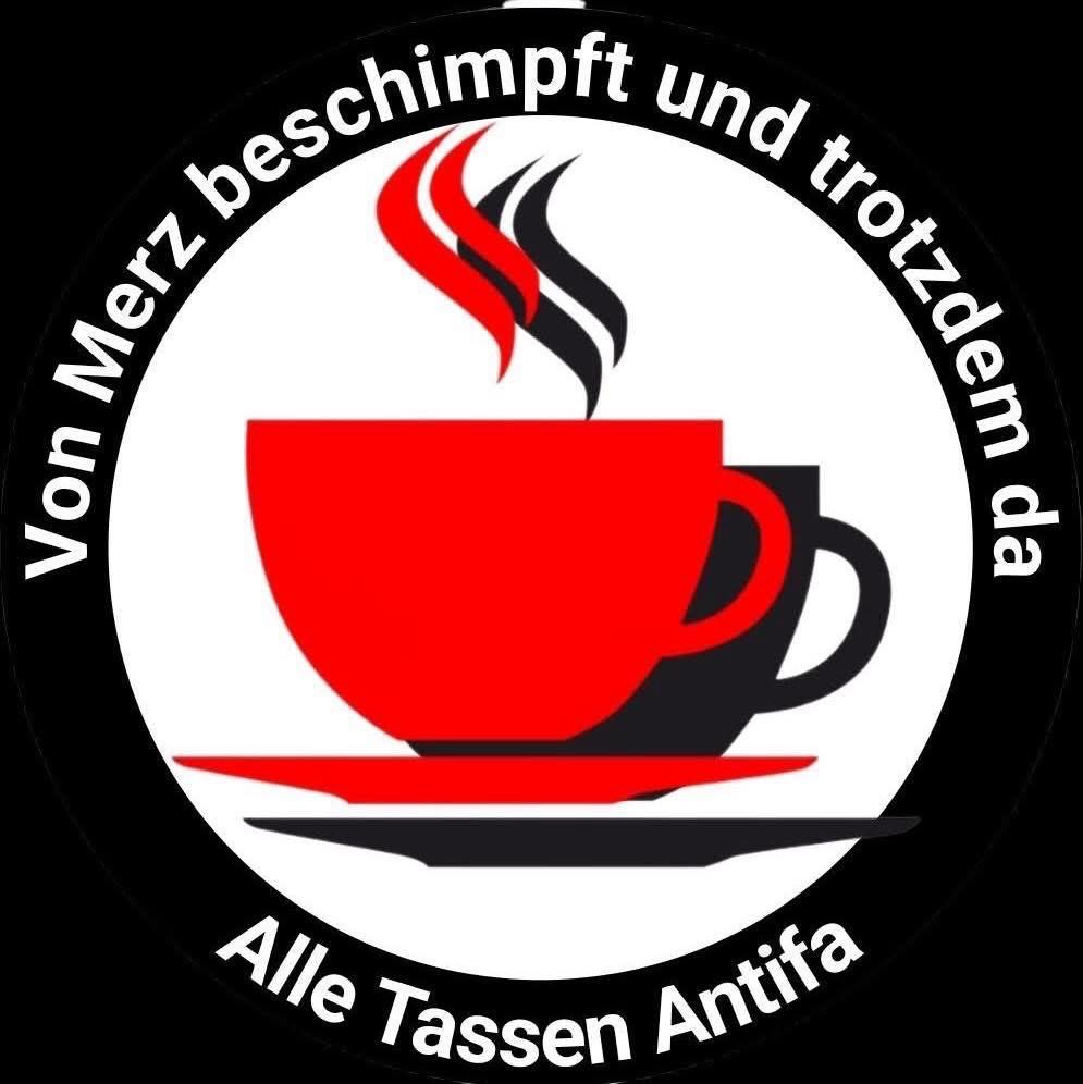 Logo mit zwei Kaffeetassen, einer roten und einer schwarzen, wobei Dampf aus der roten Tasse aufsteigt. Der Text umgibt das Bild in deutscher Sprache und übersetzt "Von Merz beschimpft und trotzdem da: Alle Tassen Antifa".