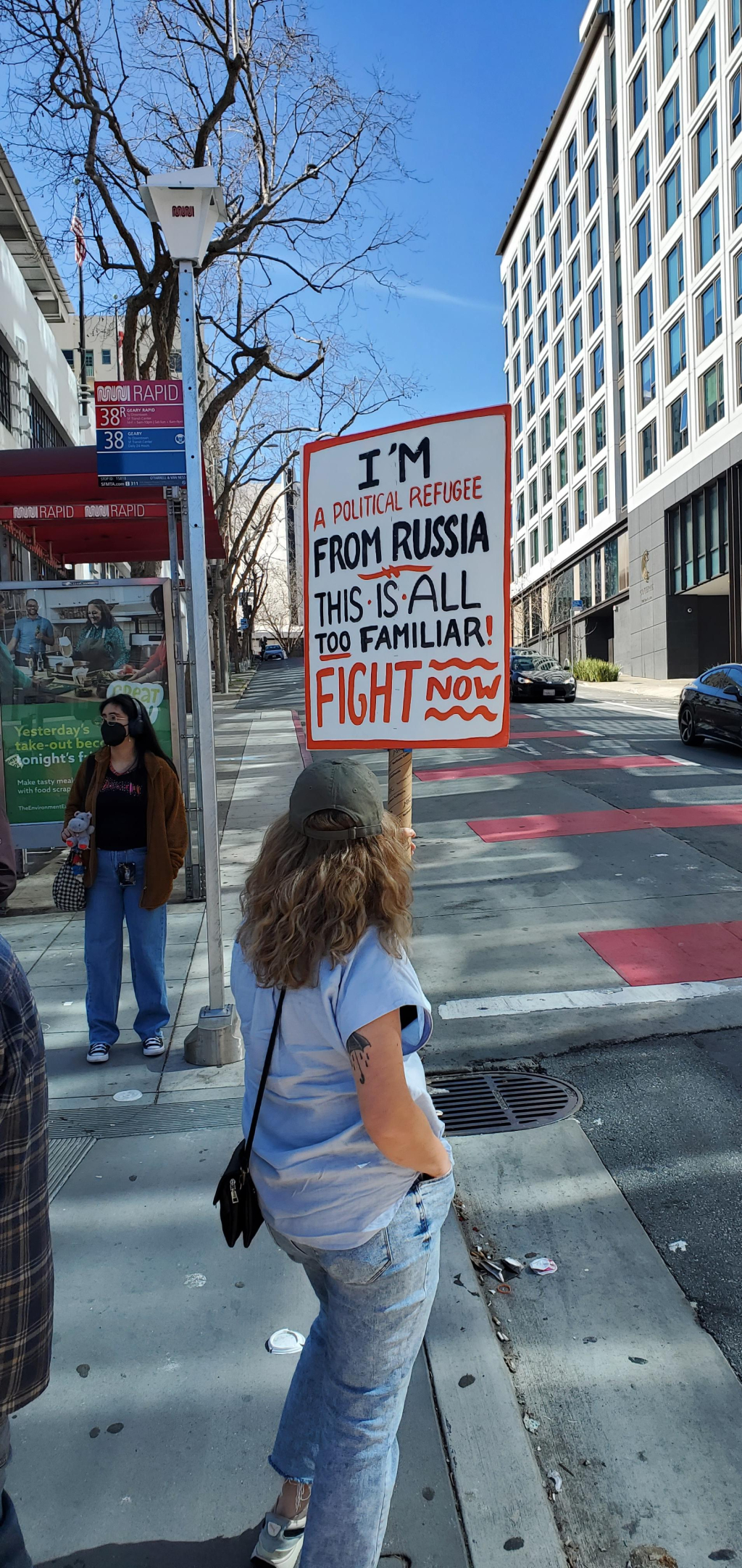 Person with picket sign: "I’m a political refugee from Russia. This is all too familiar. Fight now."