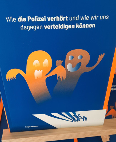 Blaues Buch. Auf dem Cover zwei Geister in Orange. Darüber steht: Wie die Polizei verhört und wie wir uns dagegen wehren können