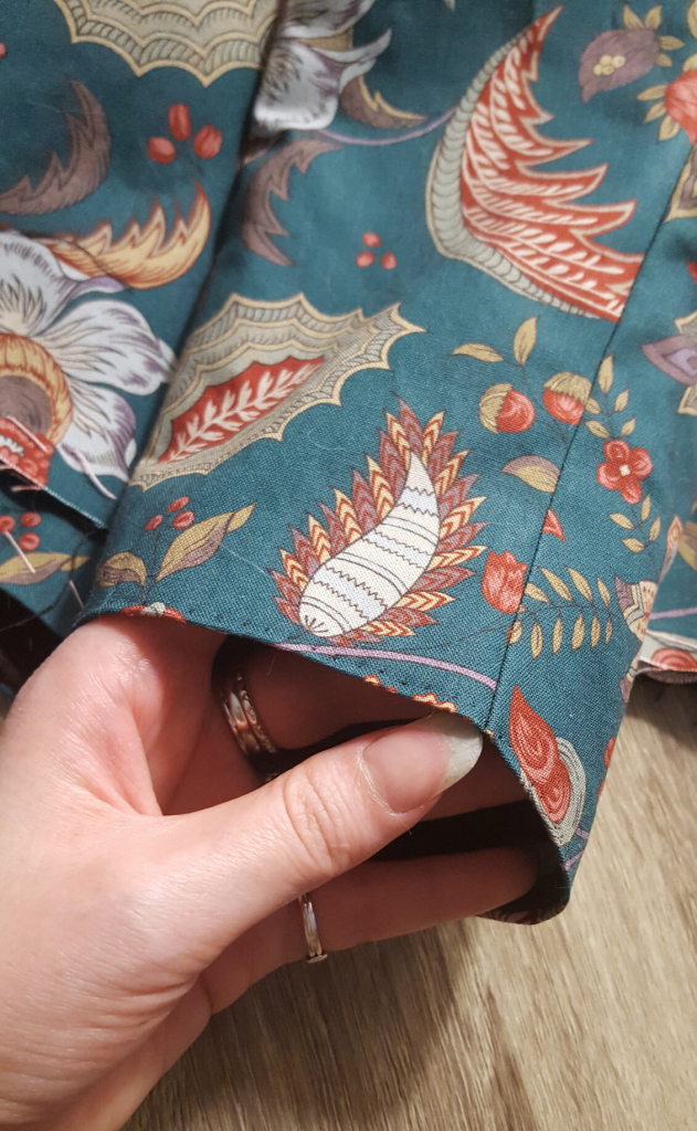 A close up of finished sleeve, its cuff nice and neat and the only seam of the one piece sleeve laying smooth and tidy, the two layers sewn as one providing some added structural integrity to the seam.