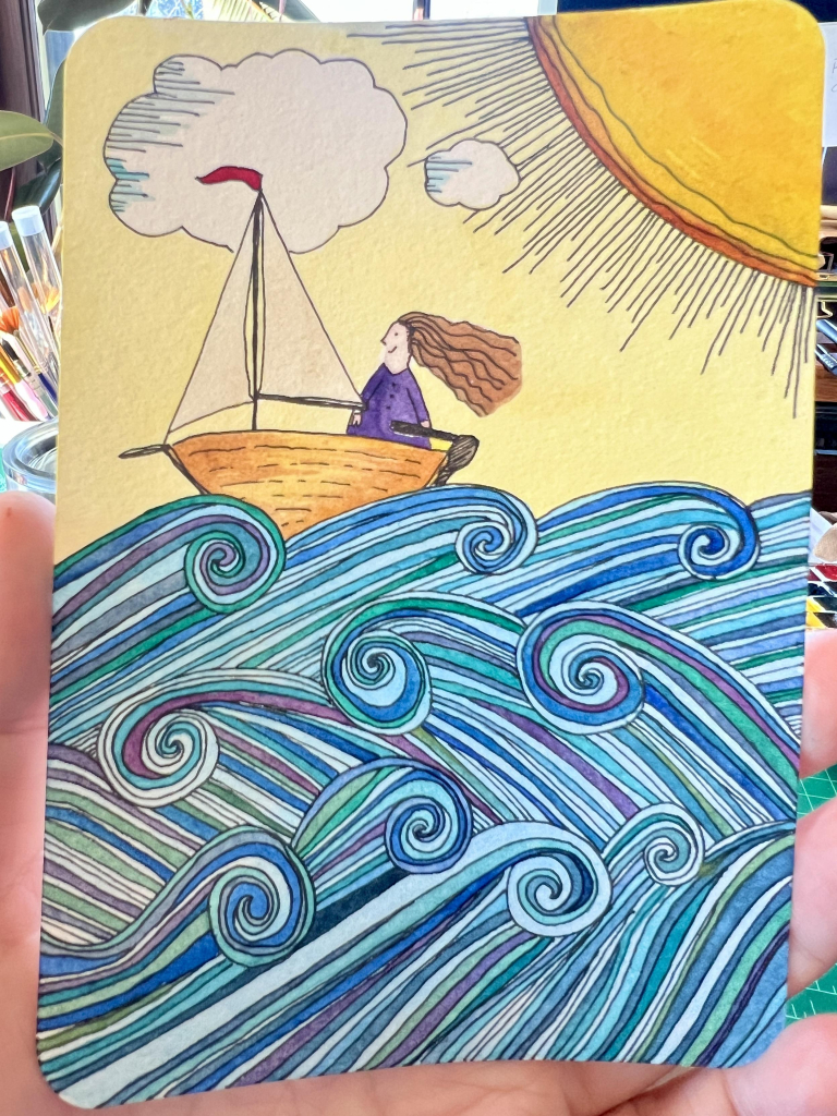 A hand holding up a watercolor postcard with a watercolor and ink drawing of a smiling person in a purple sweater standing on a little brown sailboat, long hair blowing behind them, with three big rows of rolling waves in blue-green-purple beneath them, clouds overhead, and a fat and happy yellow sun in the right hand corner. 