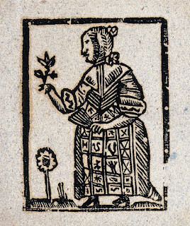 A woodcut image of a witch holding flowers