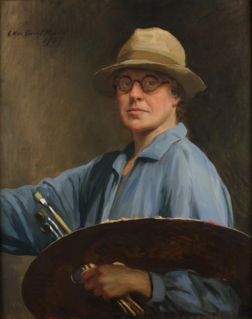 Painting of a white woman, a self-portrait of the artist, wearing a light brown hat, rounded glasses, and loose blue smock, holding a large palette over her arm and clasping several brushes in her hand. Her other hand is raised off-canvas as if painting, and she looks directly at the viewer.