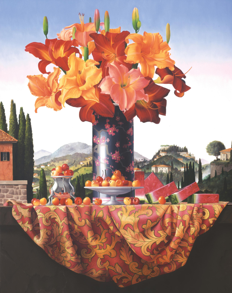 Still life painting in a photorealistic style depicting a tall dark vase holding an assortment of orange and red flowers, surrounded by cherries and watermelon slices atop a draped patterned silk textile. Behind this tableau is a green mountain landscape with cypress trees and houses, and a blue/white gradient sky.