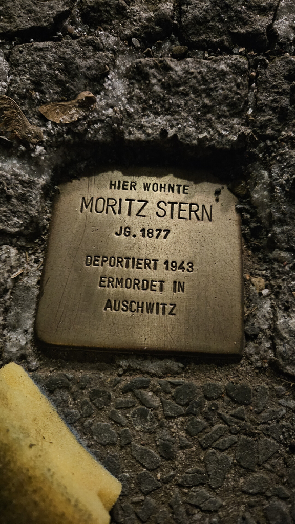 Stolperstein mit der Inschrift:

HIER WOHNTE
MORITZ STERN
JG. 1877
DEPORTIERT 1943
ERMORDET IN
AUSCHWITZ