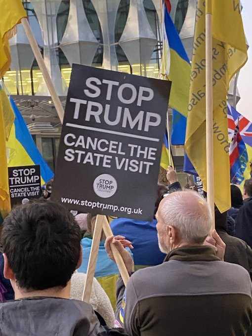 Close up of the crowd with flags and placards reading STOP TRUMP, CANCEL THE STATE VISIT