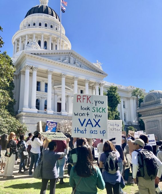 A crowd of protesters with placards at the state house in Sacramento