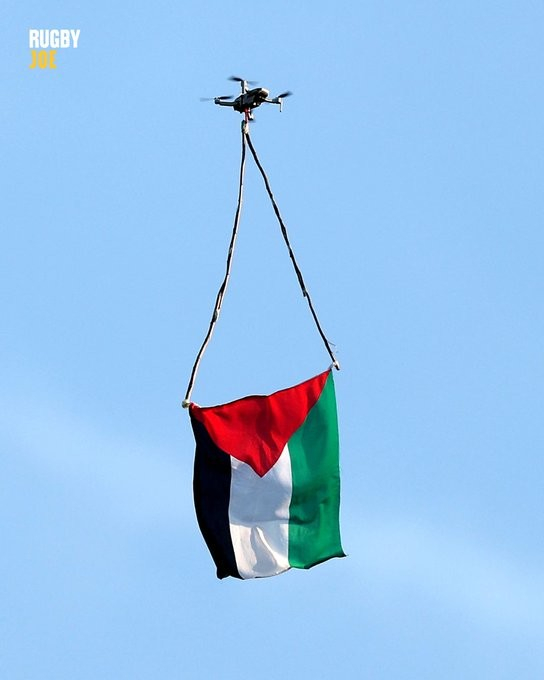 Picture of a huge Palestinian flag dangling from a drone.